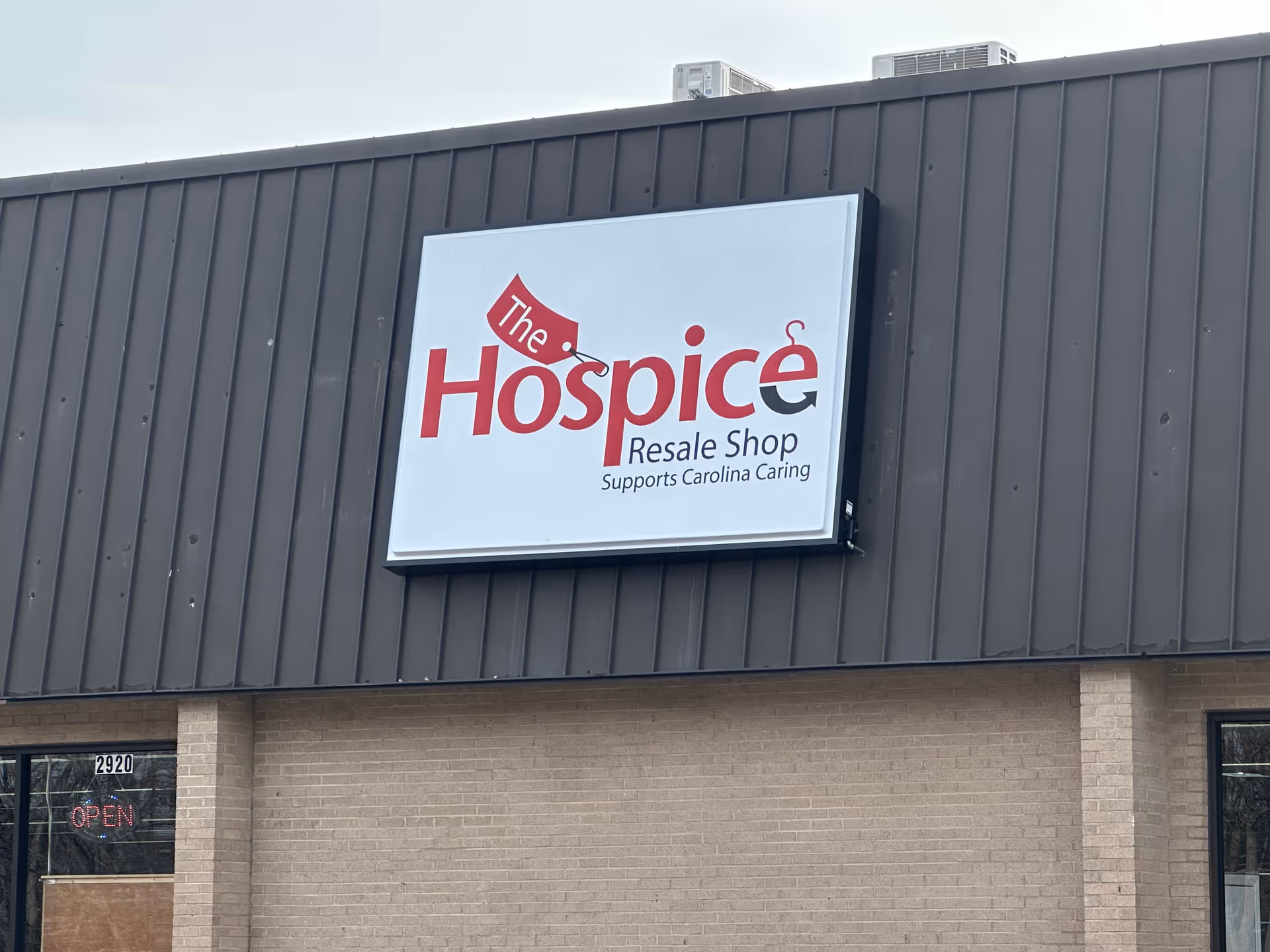 Exterior view of a building with a large sign reading The Hospice Resale Shop.