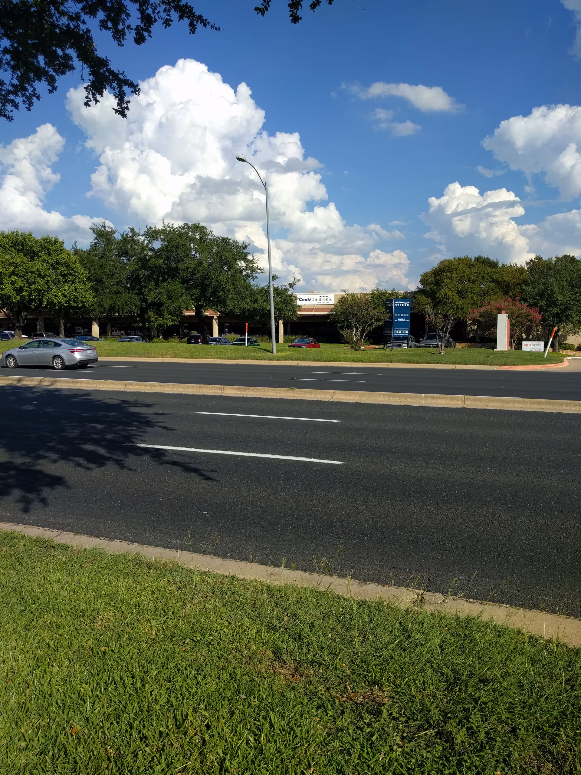 Exterior view of Cook Children's Home Health Austin building with parking lot and trees.
