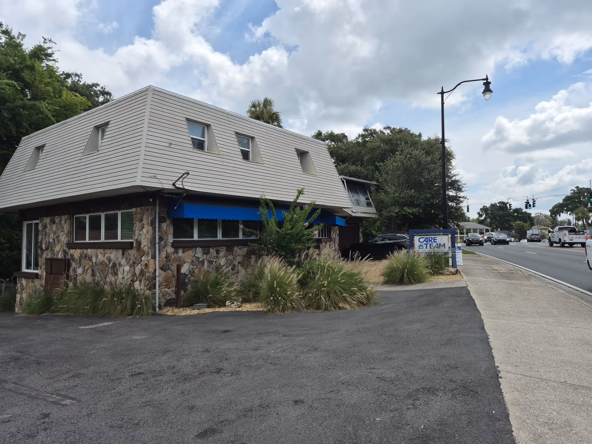 Exterior view of Care Team Home Care building with stone lower facade and blue awning.