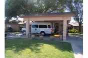 Front exterior of La Vida Serena Nursing & Rehabilitation with a white van under a porte-cochère.