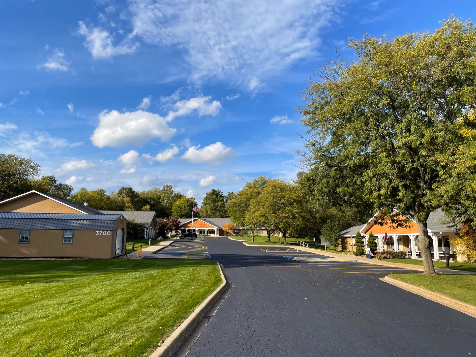 Exterior view of a senior living campus with trees, lawns, and low buildings.