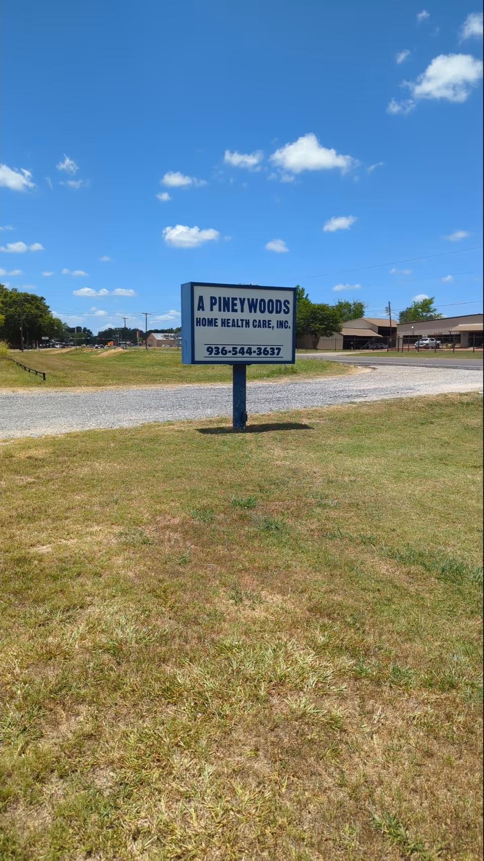 Sign for A Pineywoods Home Health Care, Inc. on a grassy lot under blue sky.