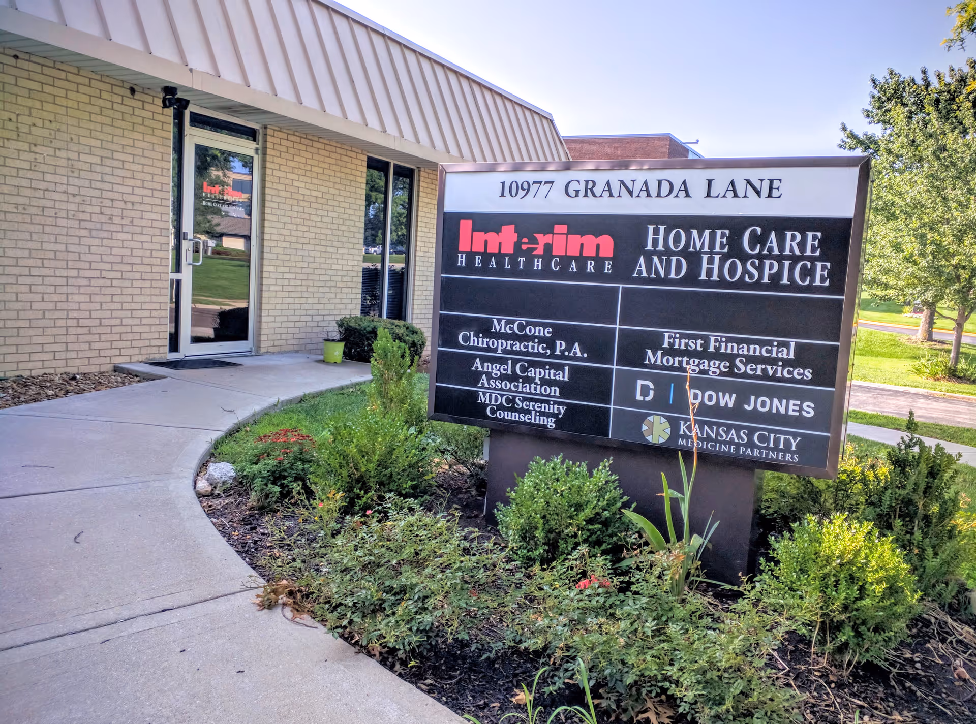 Exterior view of Interim HealthCare facility with sign and landscaped entrance at Granada Lane.