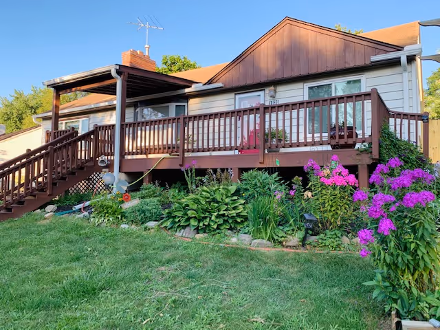 Millennium Home Senior Care: single-story building with front deck and flowering garden.