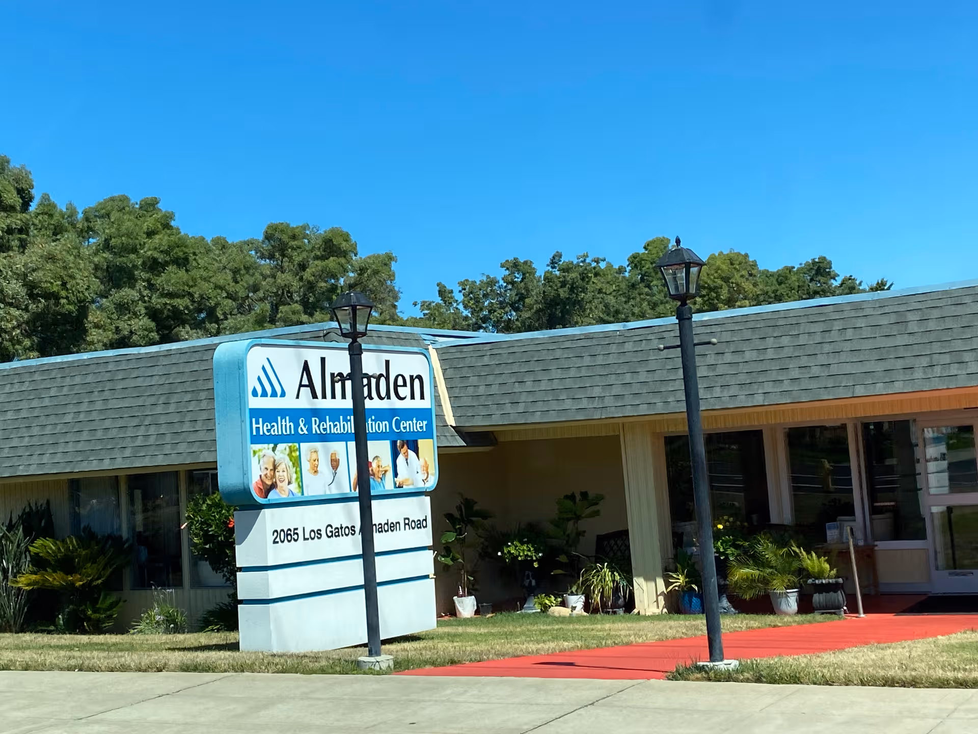 Exterior view of Almaden Health & Rehab Center with sign and entrance.