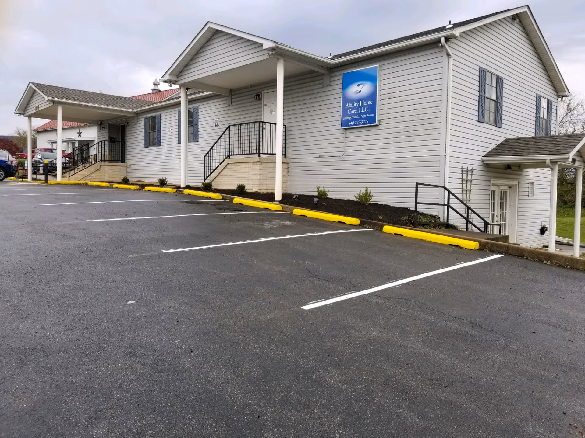 Exterior view of Ability Home Care, LLC building with a paved parking lot and ramps.