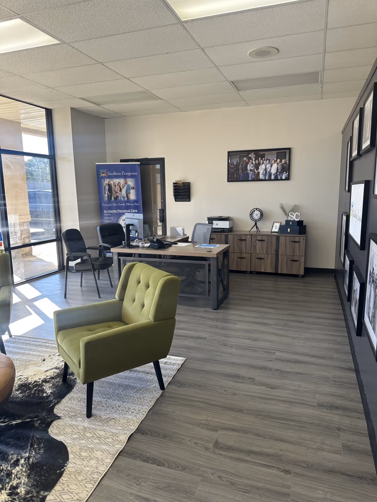Bright office lobby with green chair, desk, banner, and wall art.