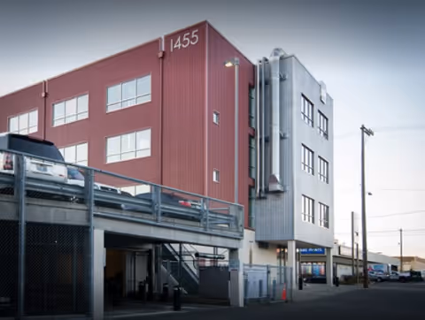 Exterior view of Reliance HomeCare building, red and gray, with a parking deck.