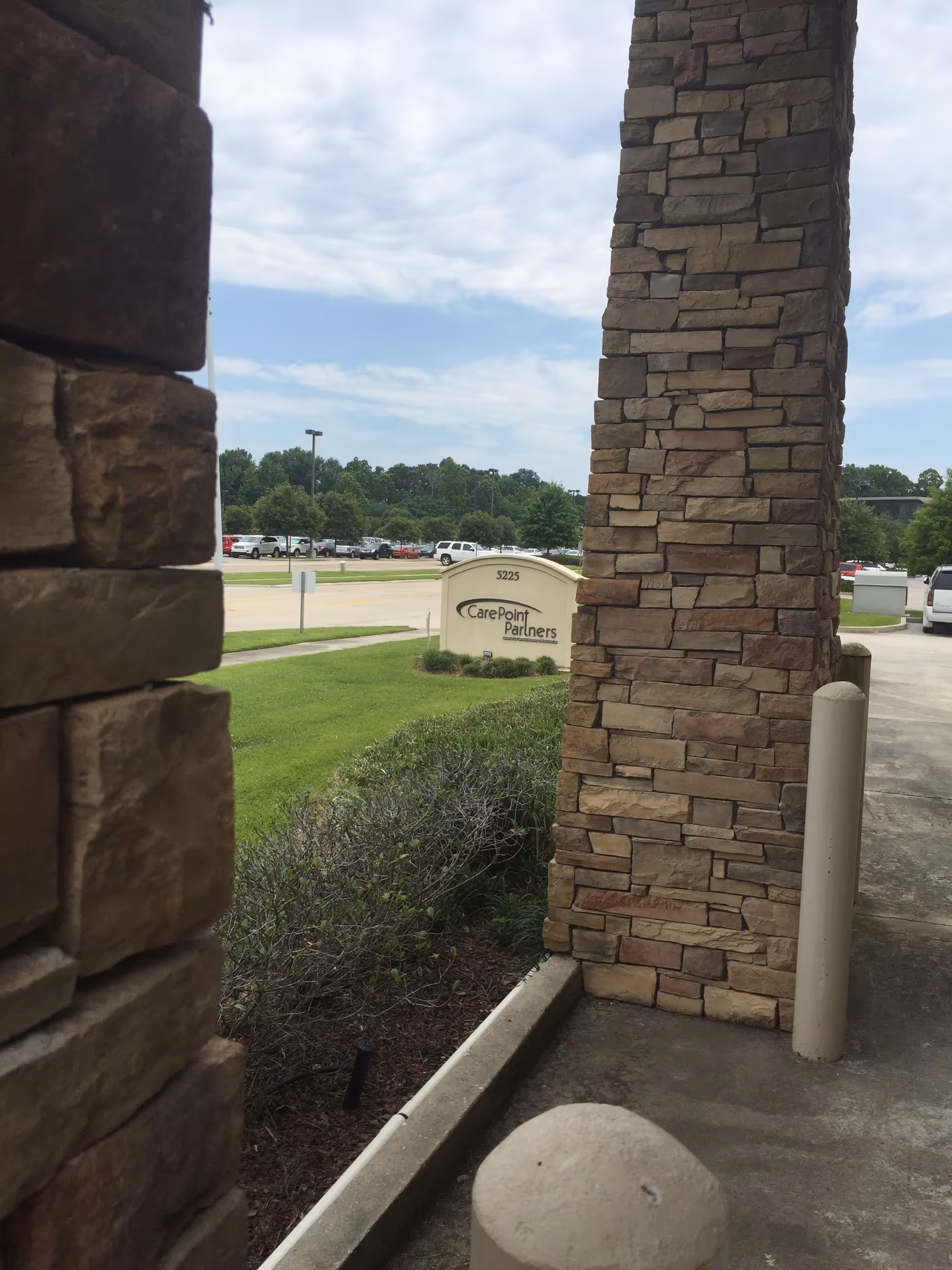 Stone columns frame a CarePoint Partners sign near a parking lot exterior.