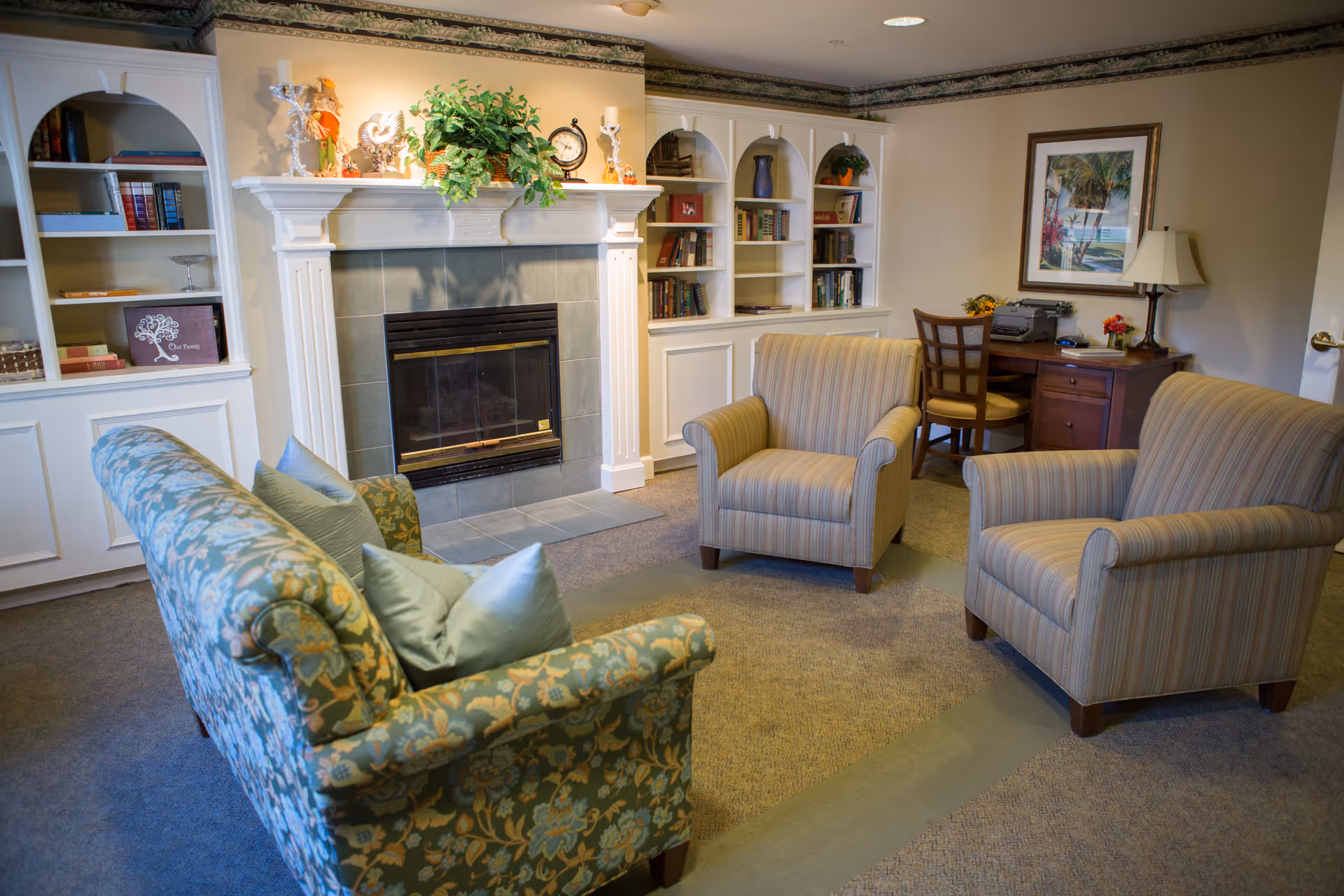 Cozy indoor senior living lounge with a fireplace, built-in shelves, and comfortable seating.