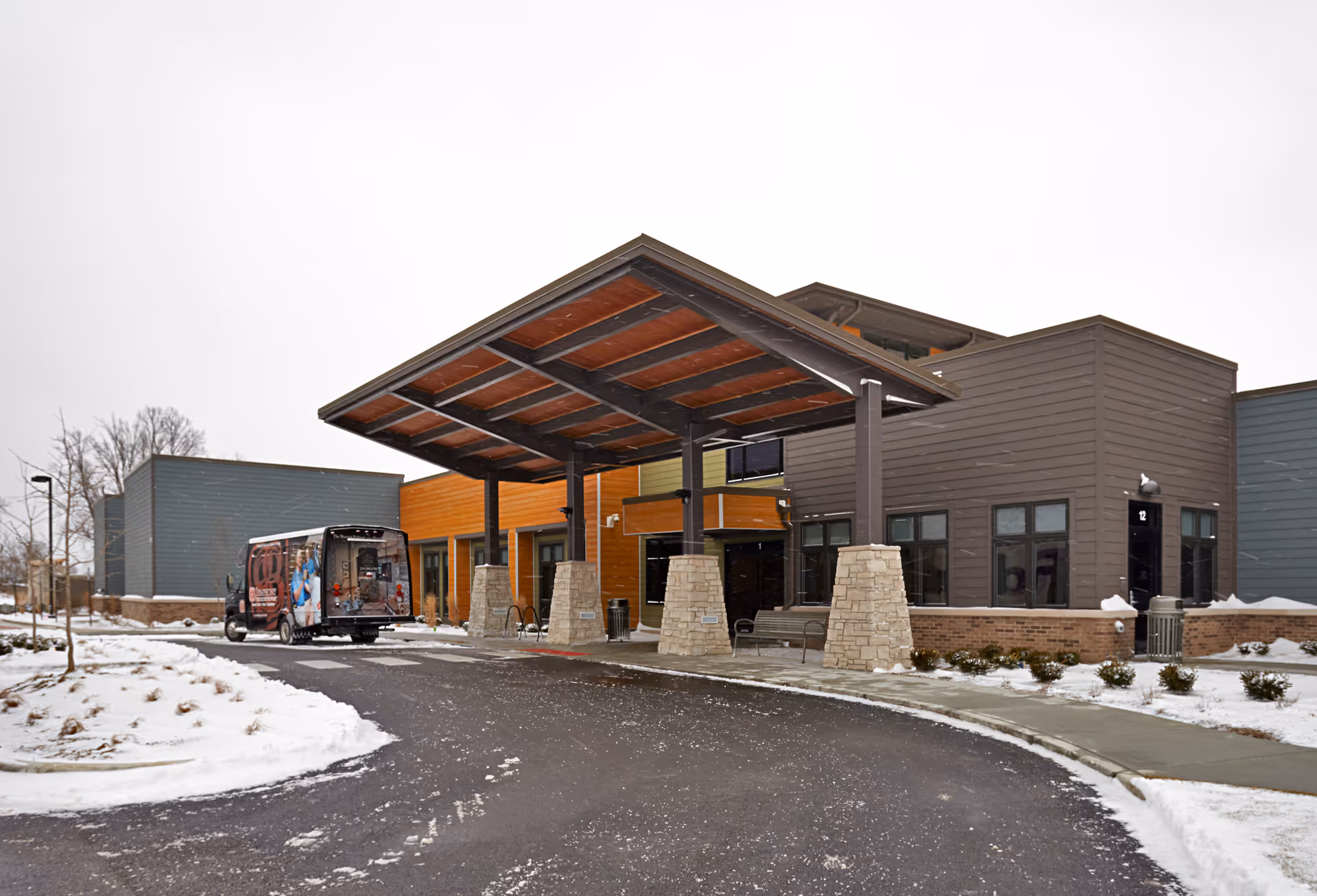 Exterior view of Symphony of Chesterton with a covered entrance and snowy parking area.