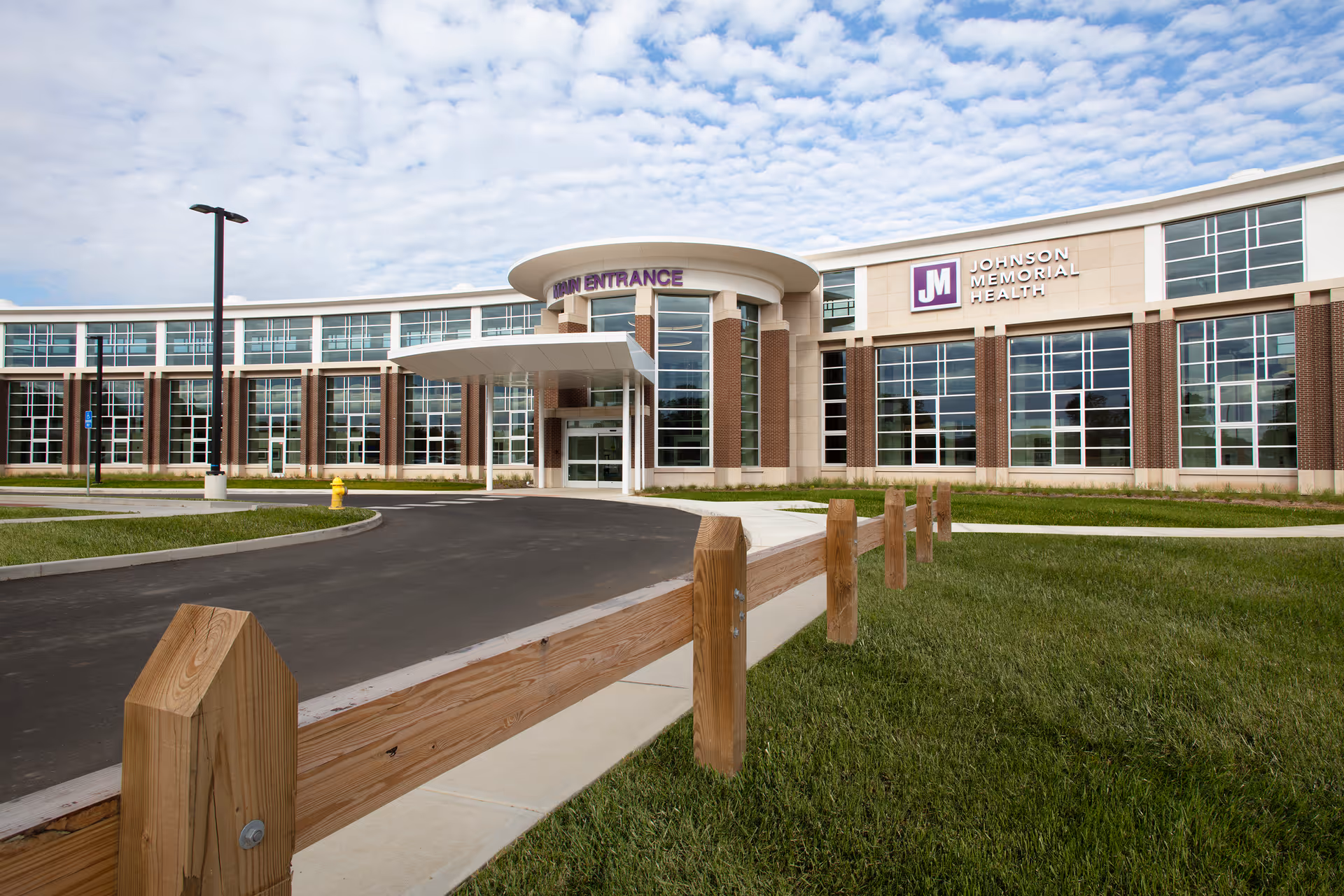 Exterior view of Johnson Memorial Health facility with glass walls and a rounded entrance canopy.