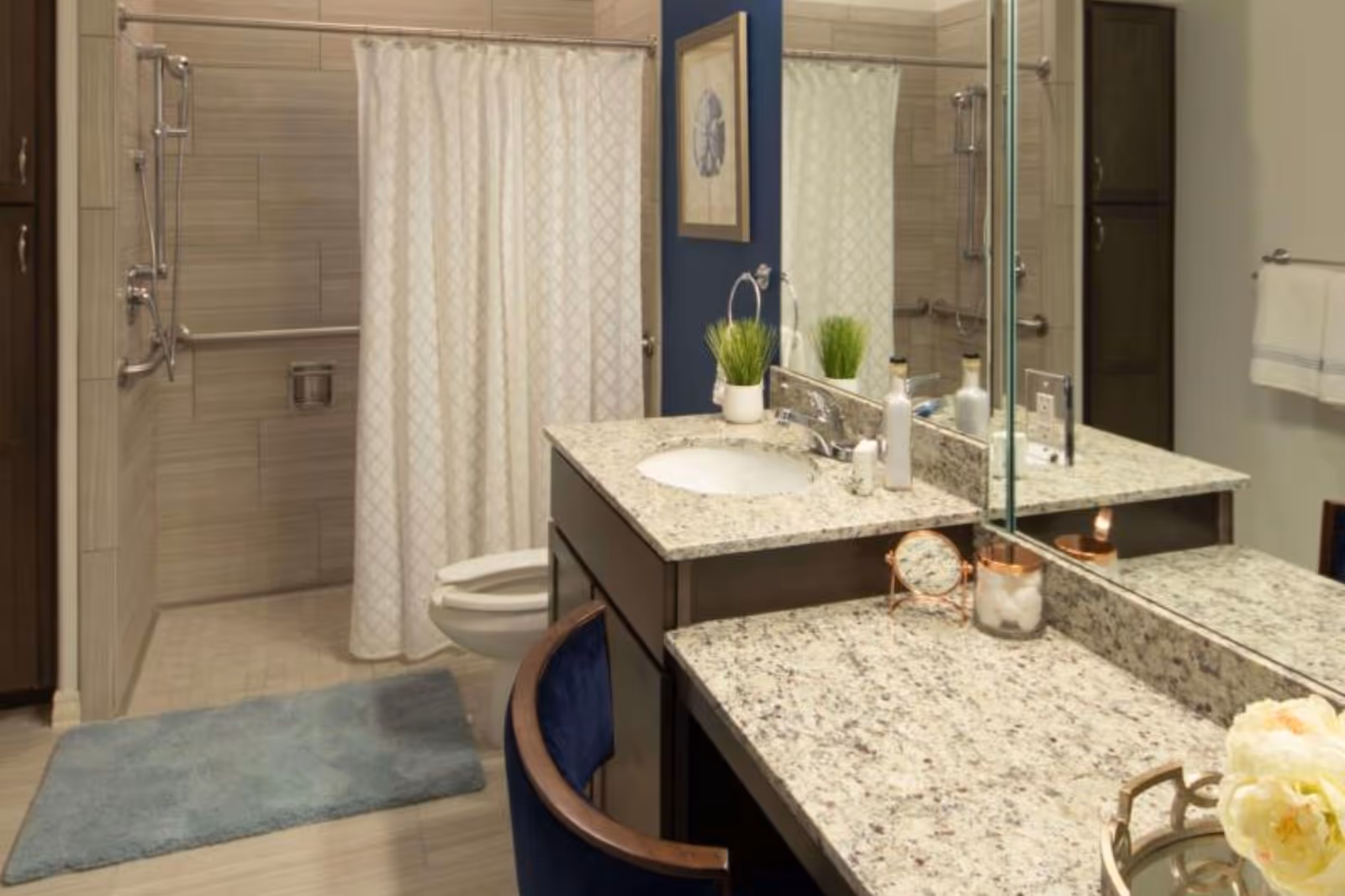 Accessible bathroom with granite countertop vanity, shower curtain, and toilet.