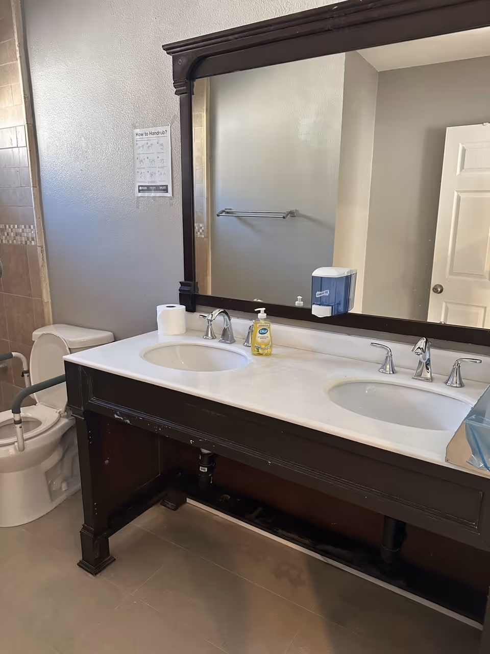 Bathroom with a double-sink vanity, mirror, and toilet at Elder Joy Oasis.
