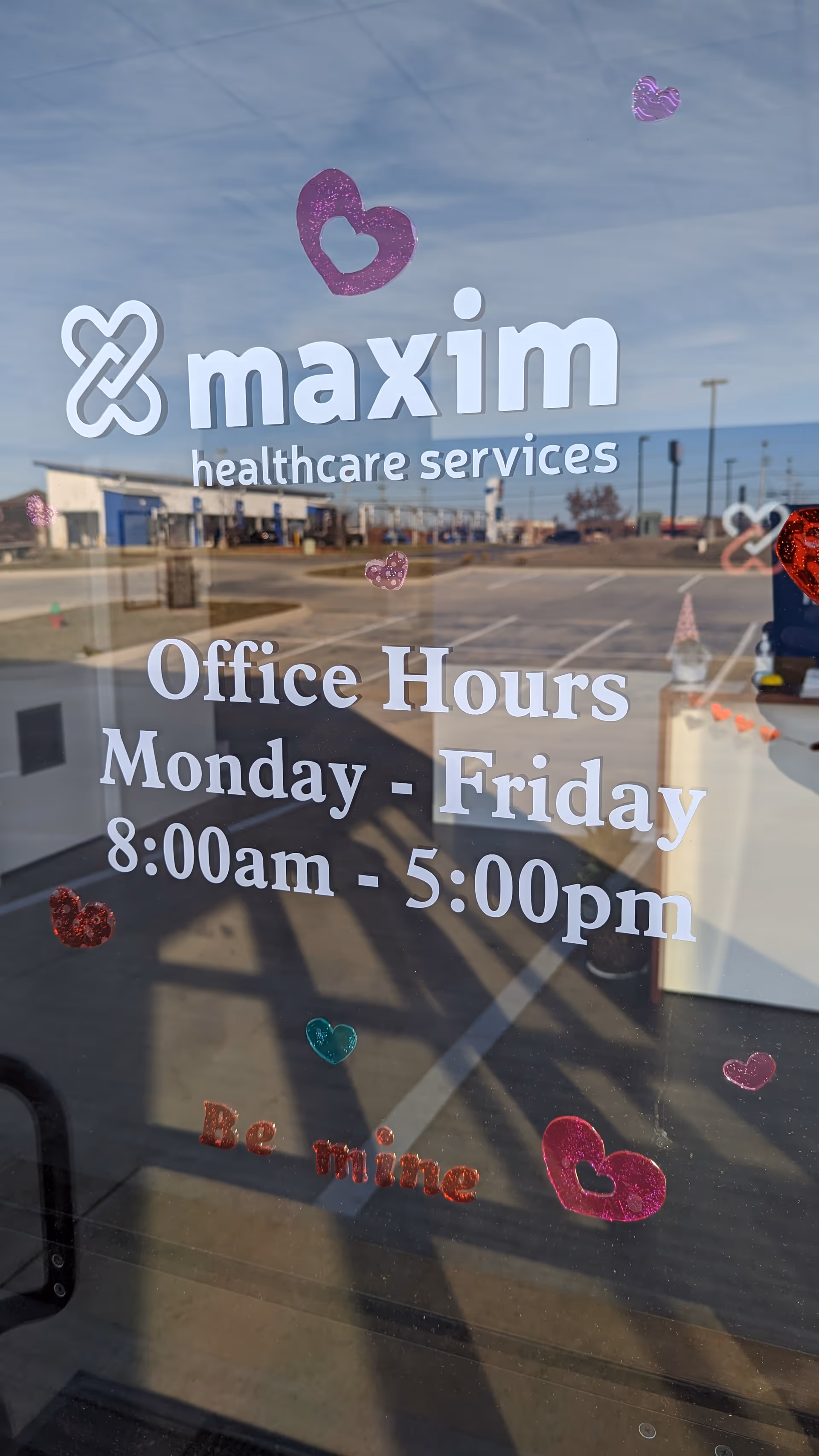 Glass storefront displays Maxim Healthcare Services signage and office hours outside Clarksville, TN.