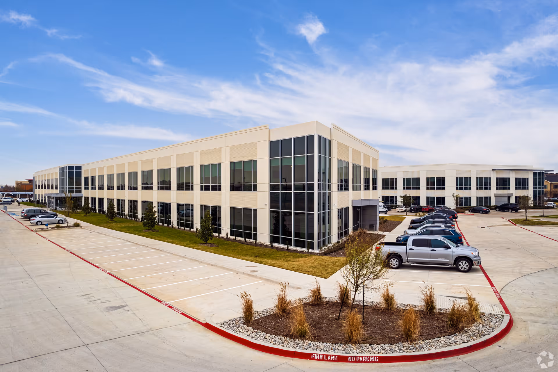 Exterior view of Lifted Hospice - Plano building with glass windows and parking.