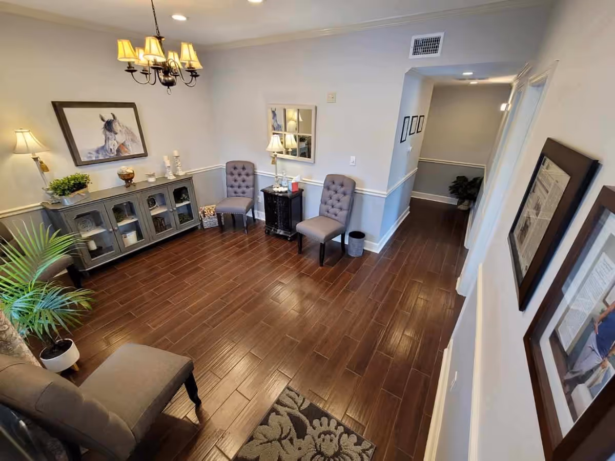 Cozy lounge area with chairs, a console cabinet, lamps, and wall art.