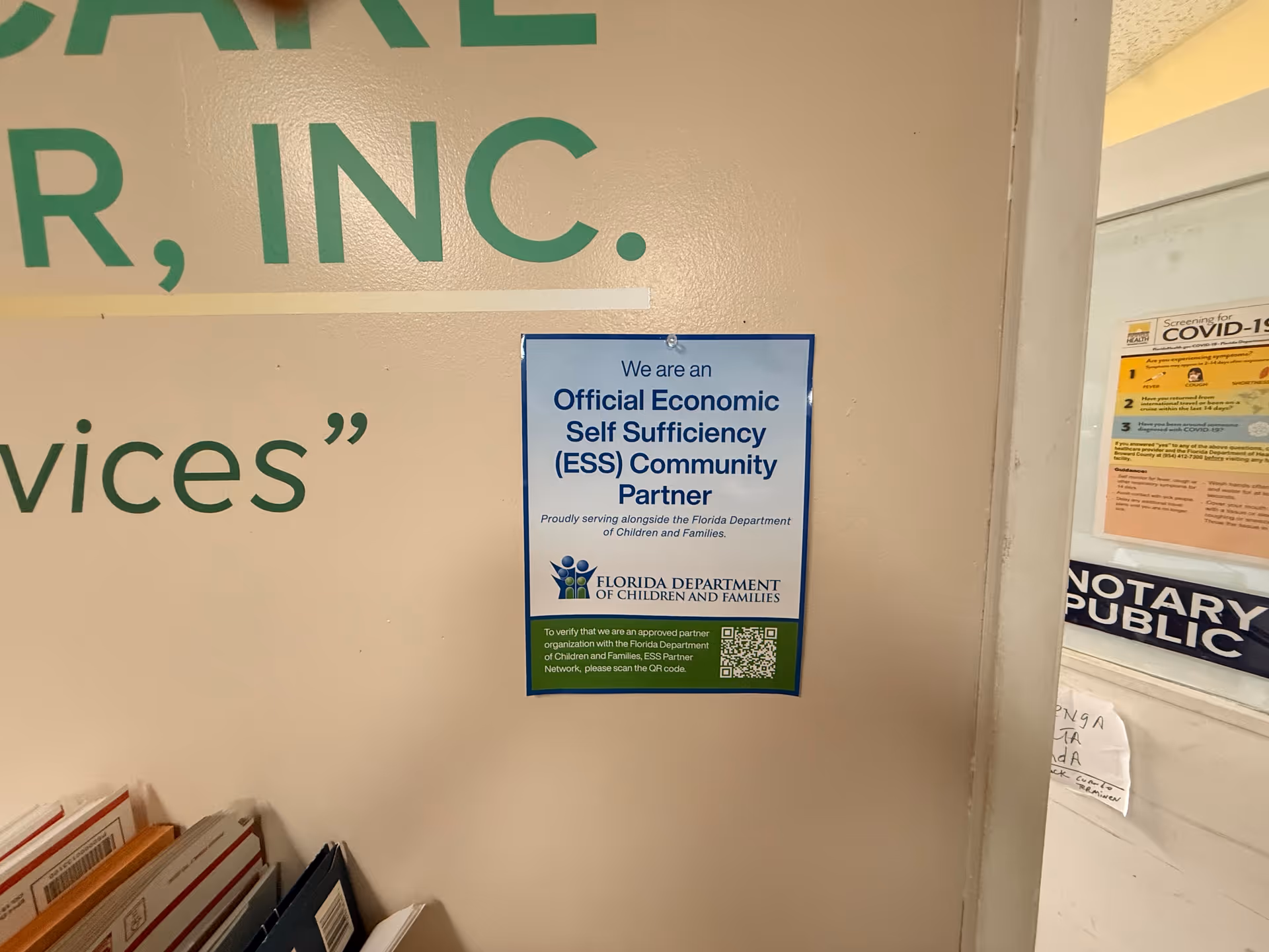 Indoor wall with a blue ESS partner poster and green text on beige background.