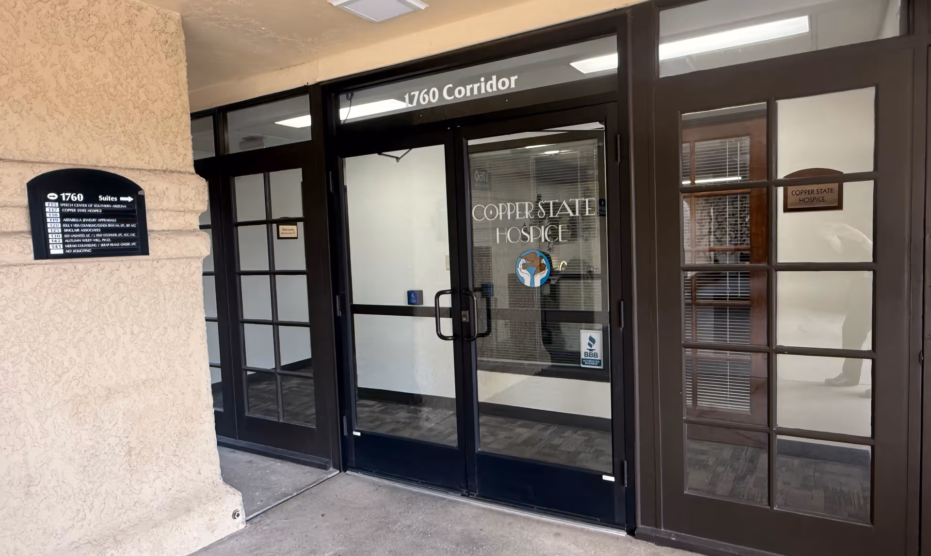 Entrance to Copper State Hospice with glass doors and a hallway beyond.