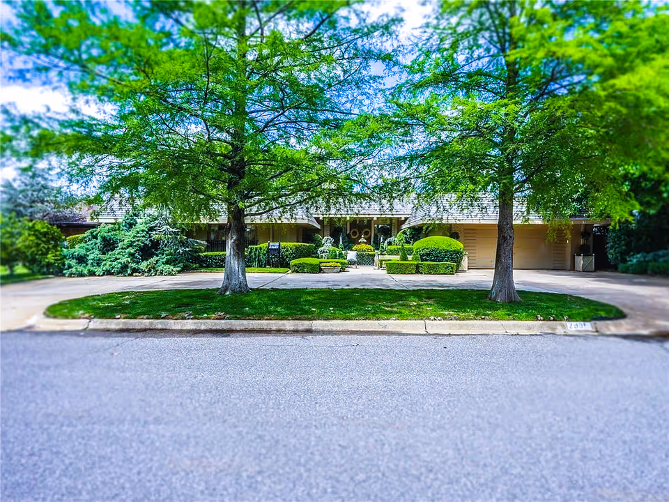 Exterior view of The Living Dynasty facility with green landscaping and a tree-lined entrance.