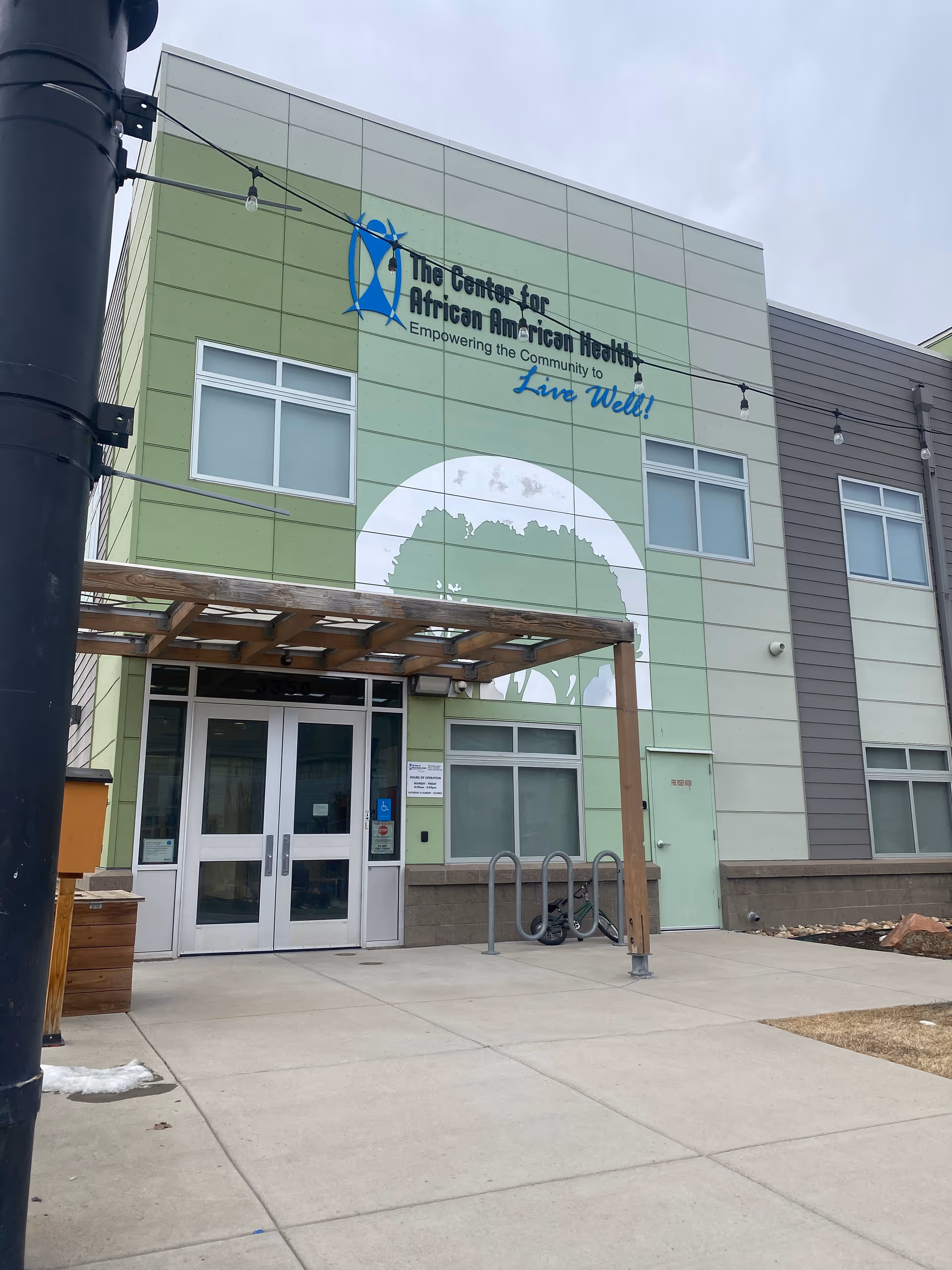 Green modern building facade with Center for African American Health sign and entrance