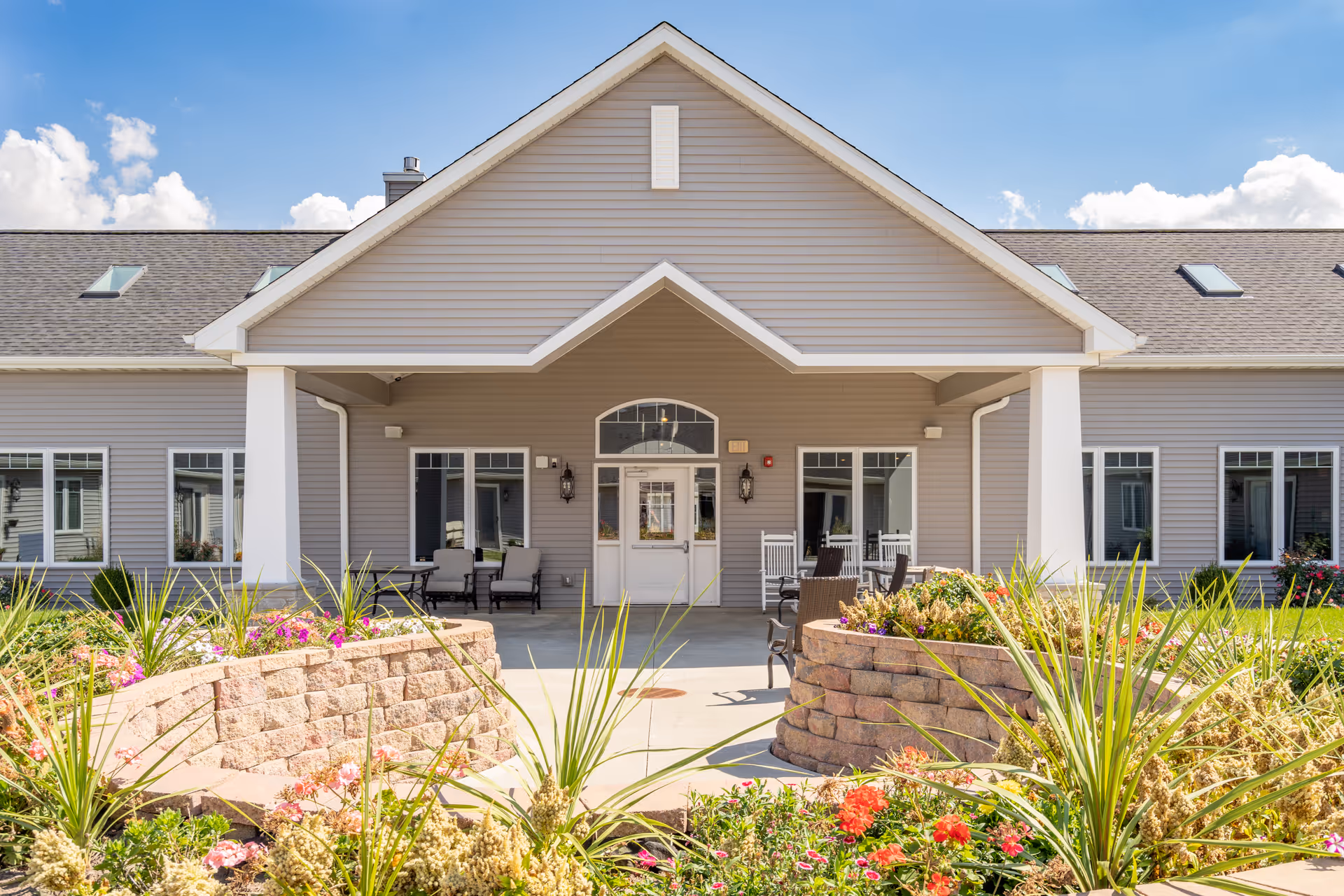 Front entrance of Villas of Holly Brook with a covered porch and landscaped beds.