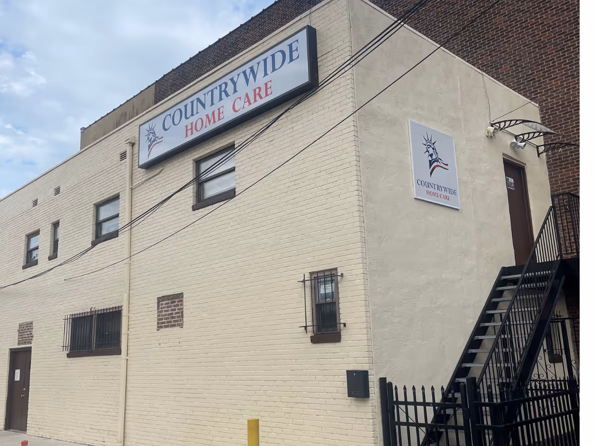 Exterior view of Countrywide Home Care building with stairs, beige brick walls, and signage.