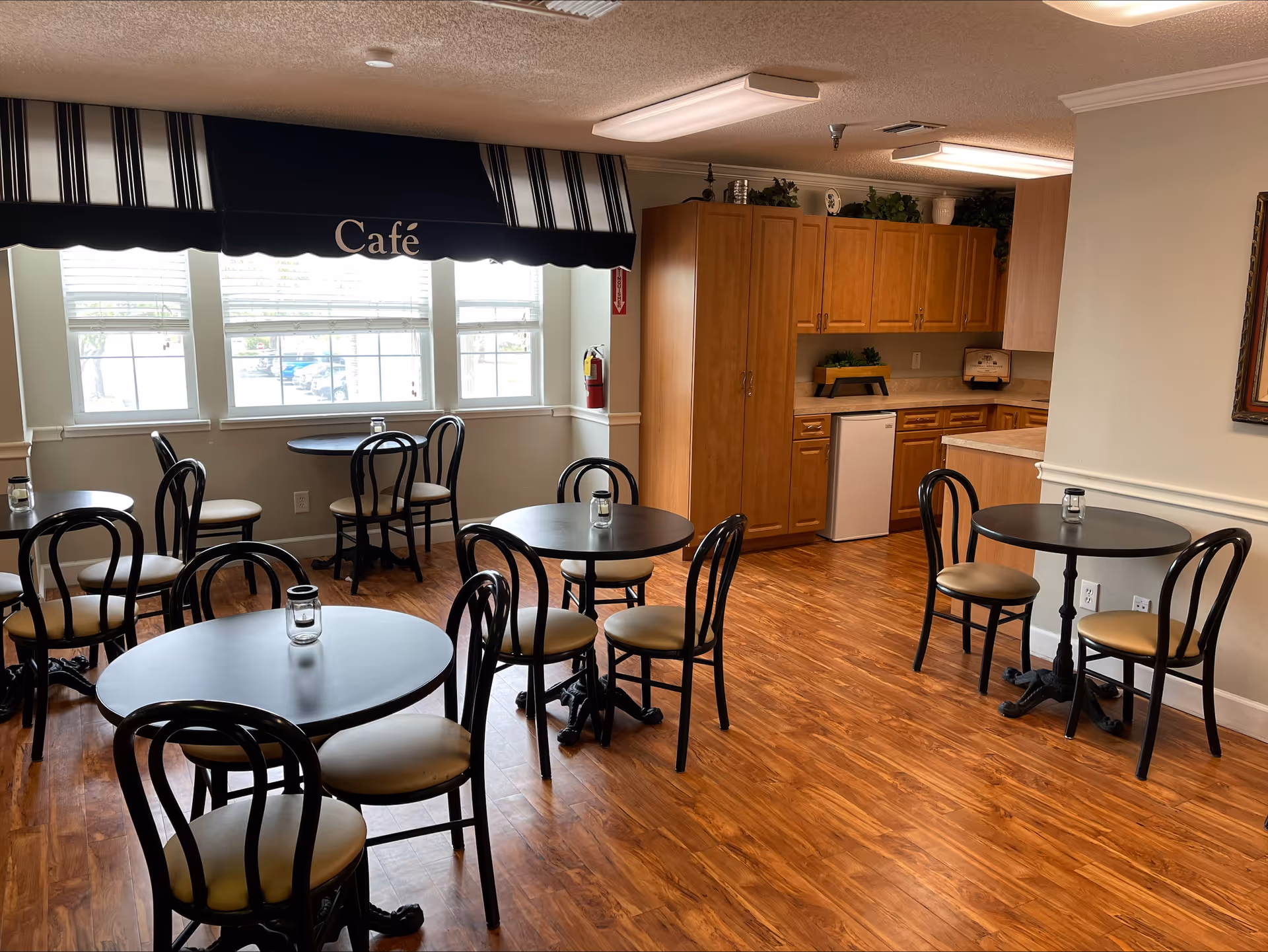 Indoor cafe area at Volante of Largo with round tables and a kitchenette.