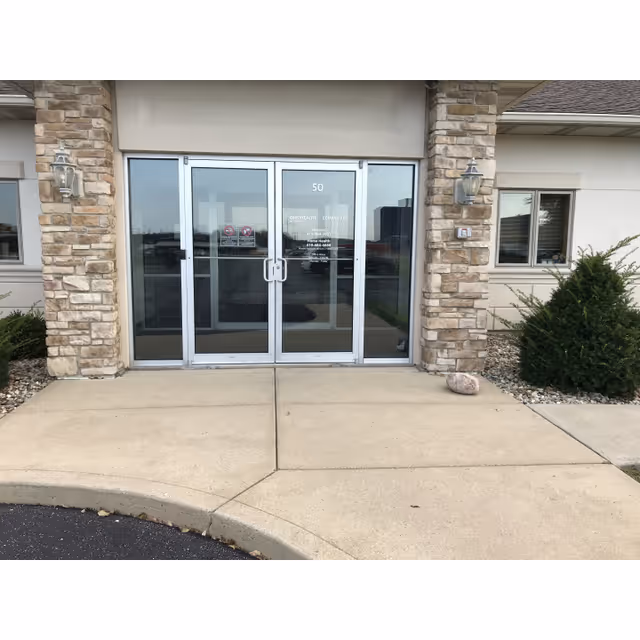 Glass double doors framed by stone columns at the building entrance.