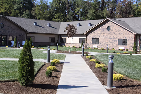 Exterior view of Margate Health And Rehab Center with a walkway and landscaped grounds.