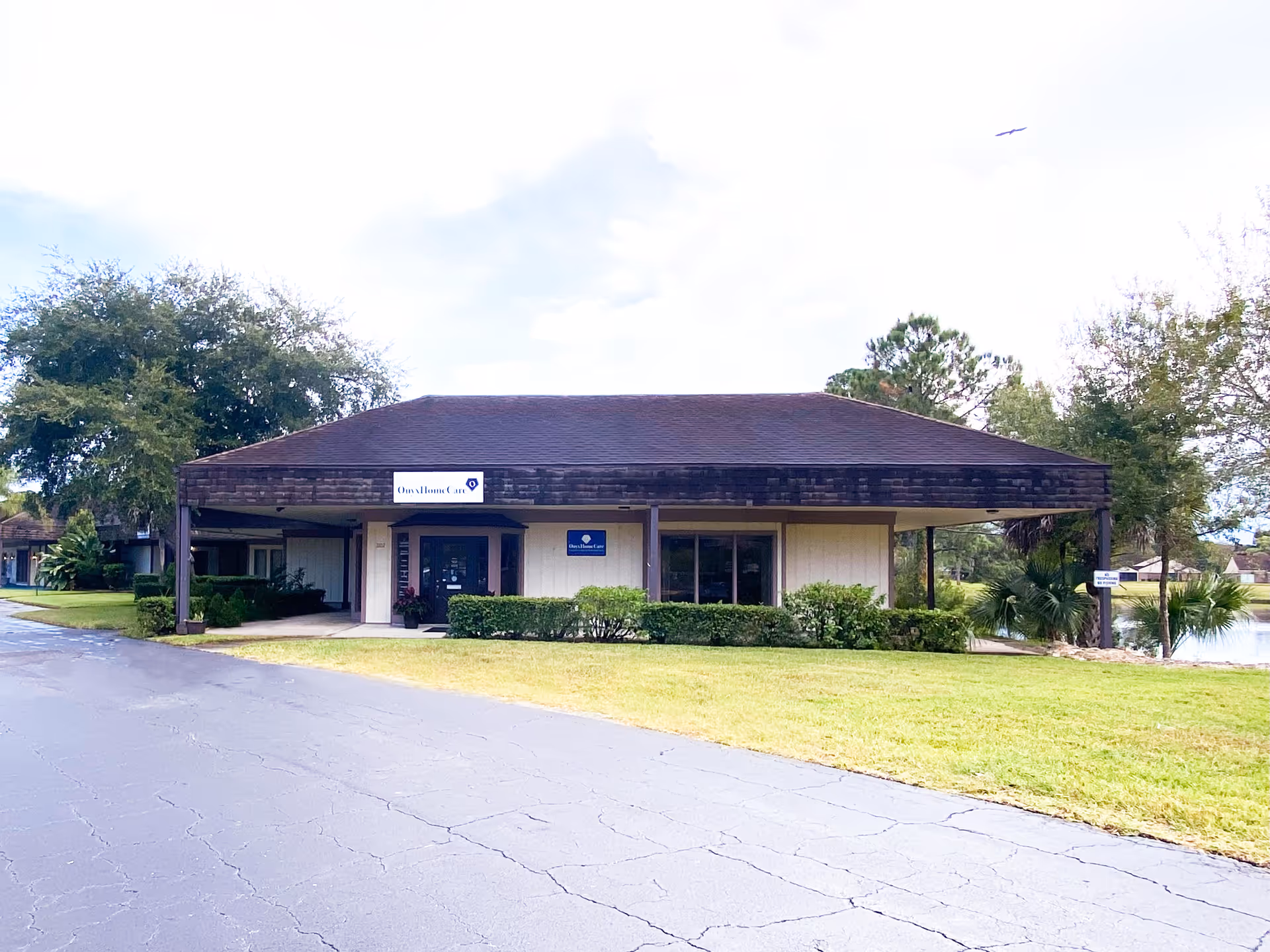 Exterior view of a single-story building with a covered entrance and landscaped surroundings.