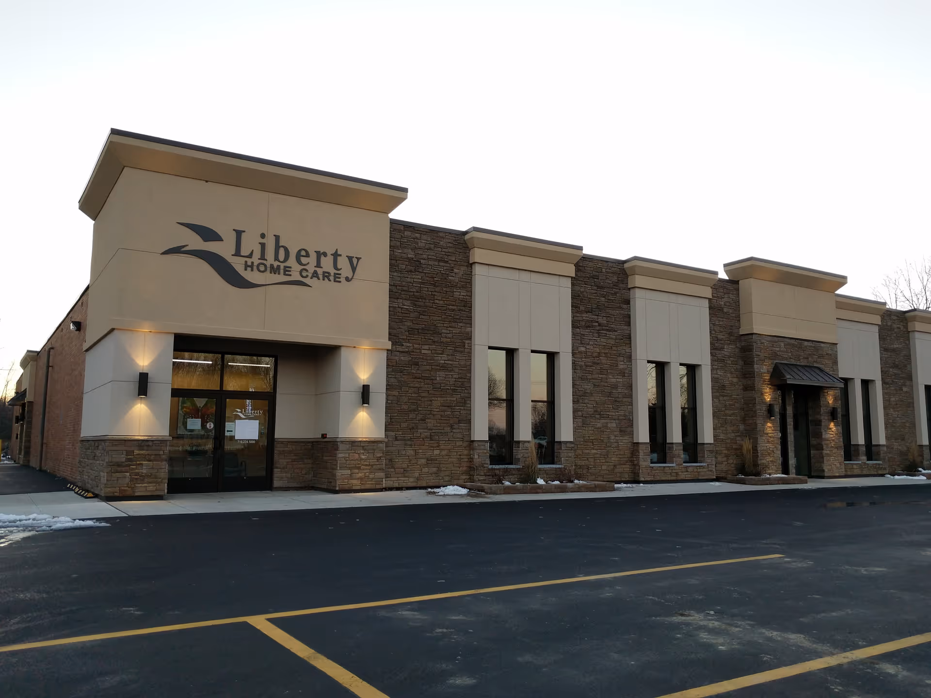 Exterior view of Liberty Home Care building with stone façade and glass entry