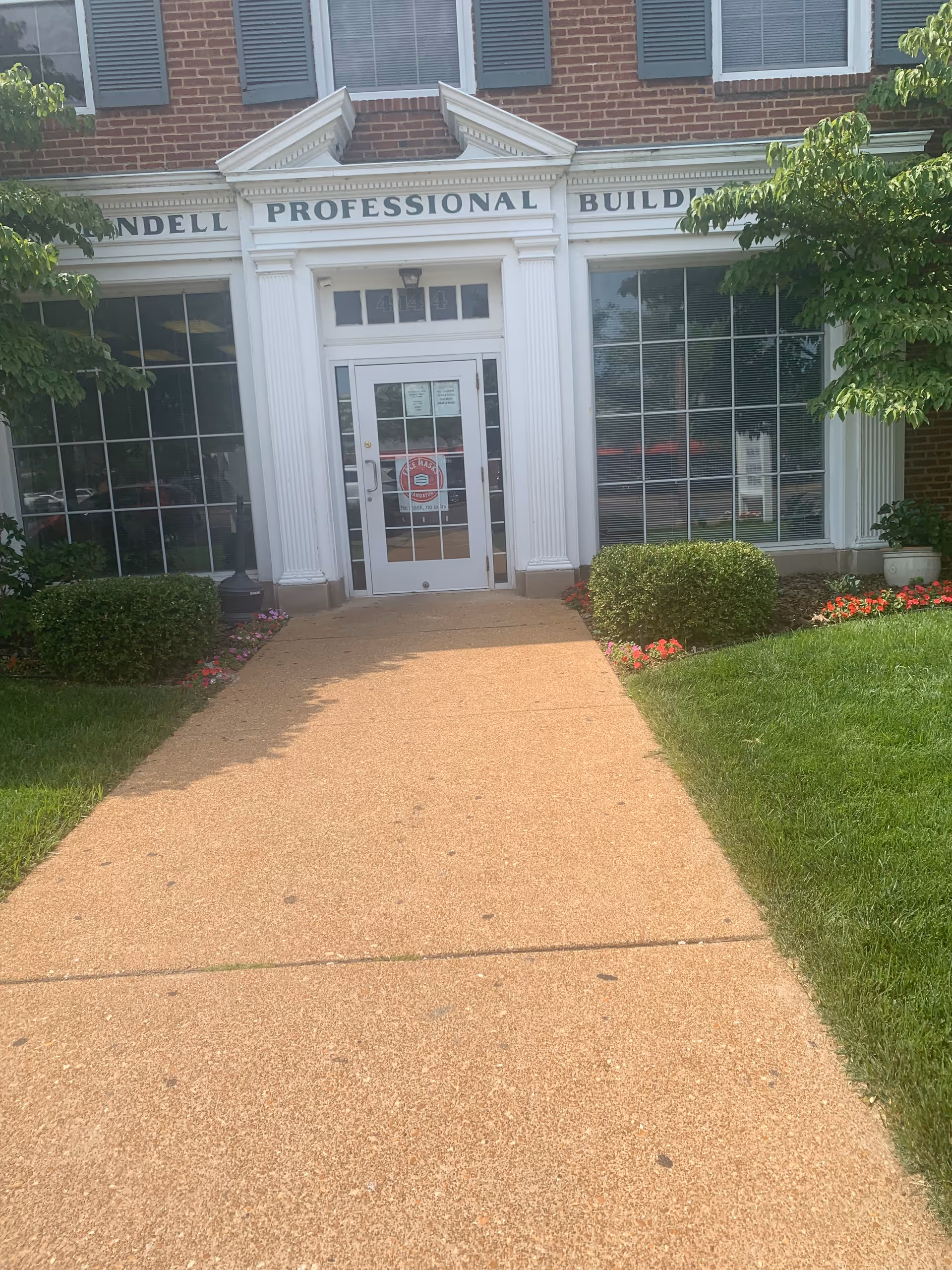 Front entrance of a senior living facility with white columns and glass doors.