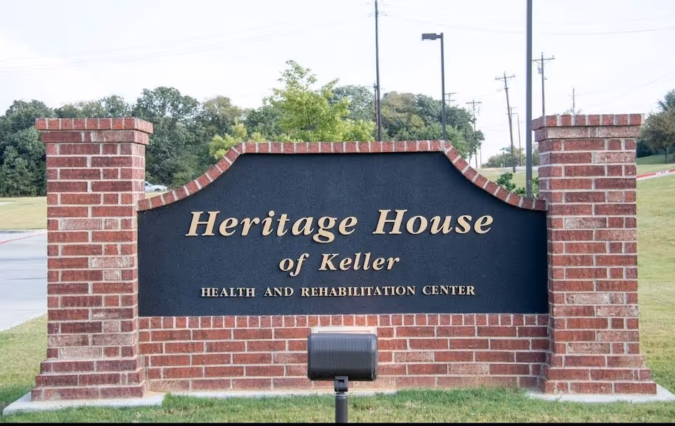 Brick sign at entrance reads Heritage House of Keller Health and Rehabilitation Center.