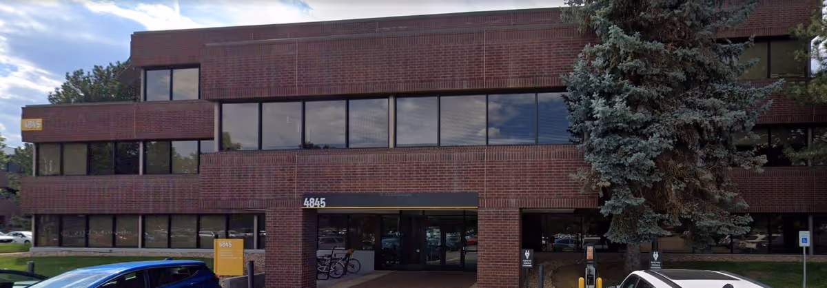 Brick, two-story facility exterior with large windows and a visible entrance.