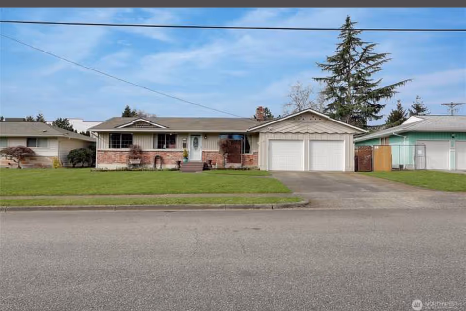 Front view of a single-story house with a two-car garage and front yard.
