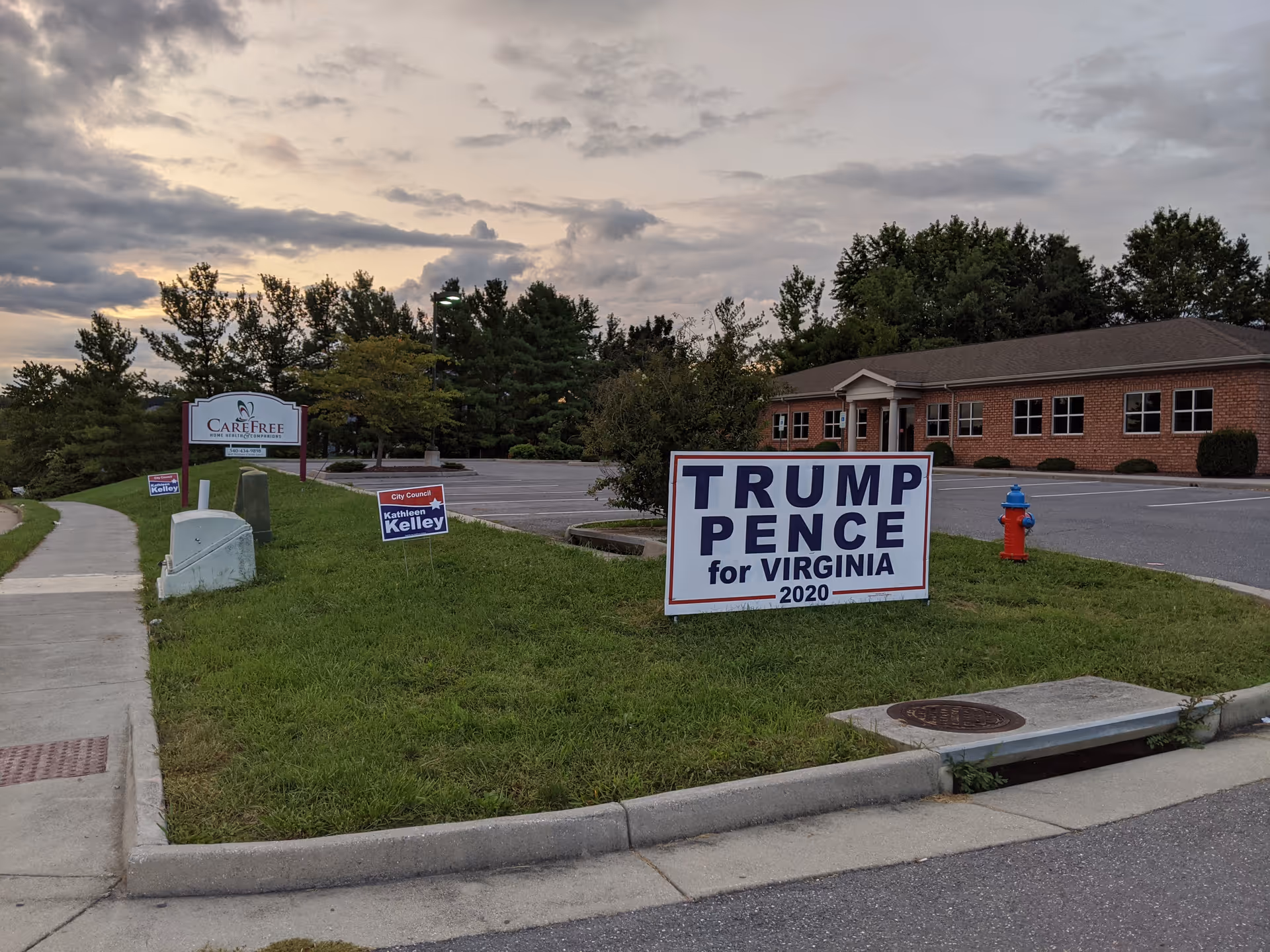 Exterior view of CareFree facility with campaign signs on a grassy median.