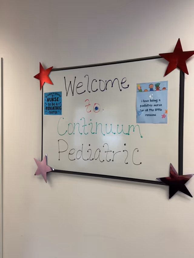 Whiteboard sign on wall reading Welcome to Continuum Pediatric Nursing Services, decorated with stars.