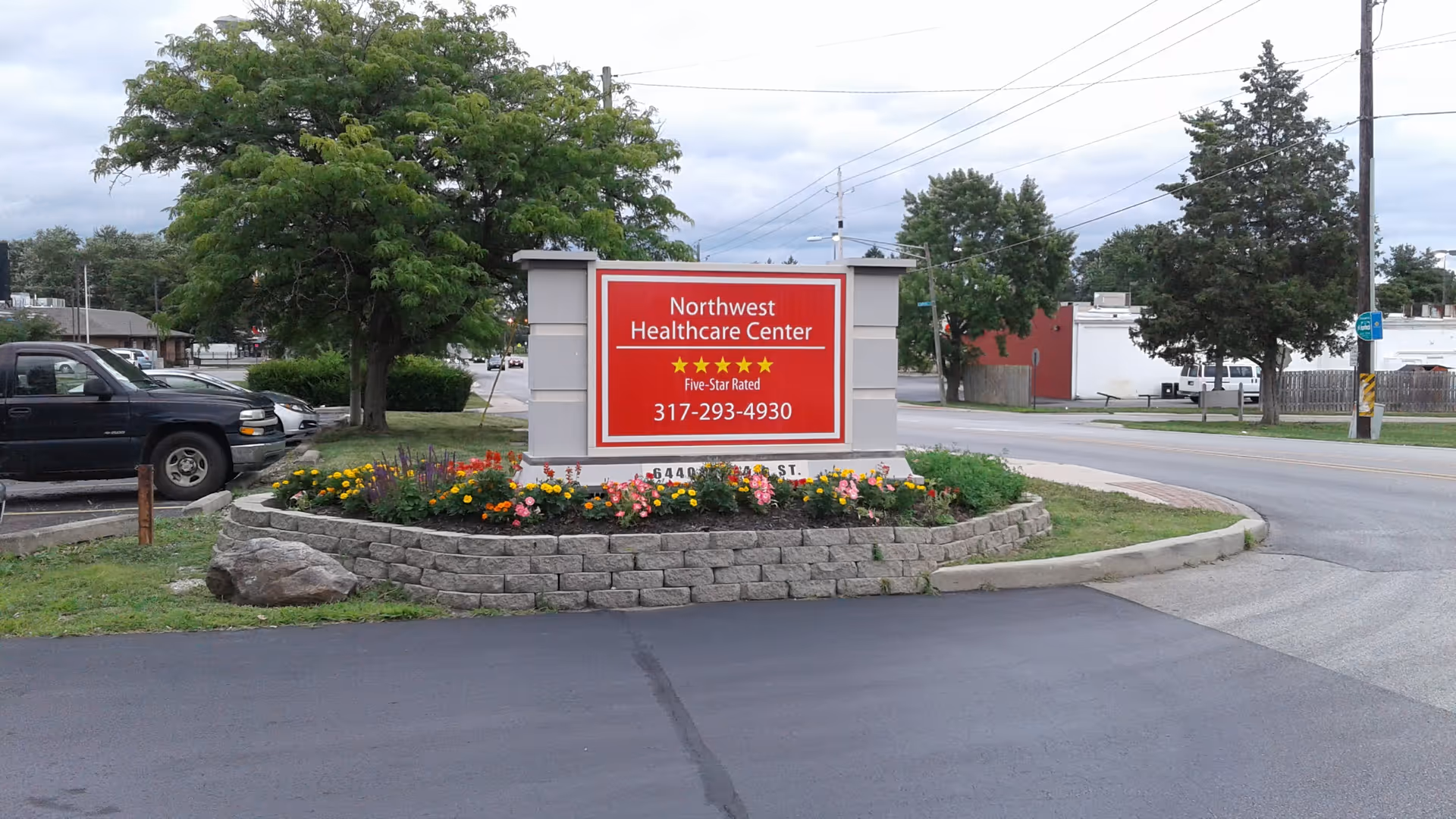 The Northwest Healthcare Center sign surrounded by flowers in a circular stone bed.