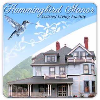 Front exterior of a manor-style assisted living facility with a wraparound porch.