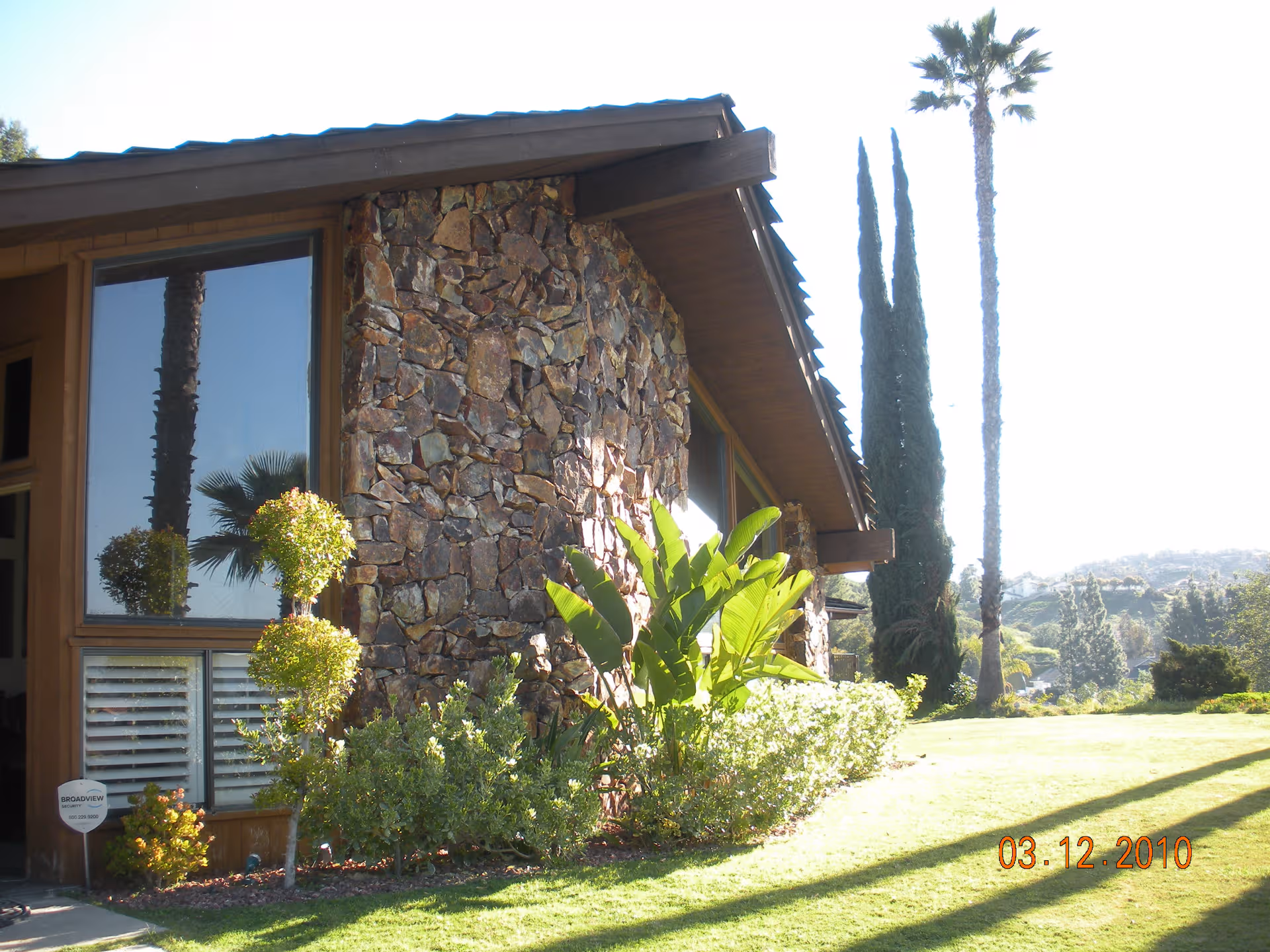 Exterior view of Villa Alegre Senior Care Homes showing stone facade, window, and landscaping.