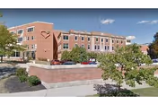 Exterior view of a brick senior living facility with landscaped front planters.