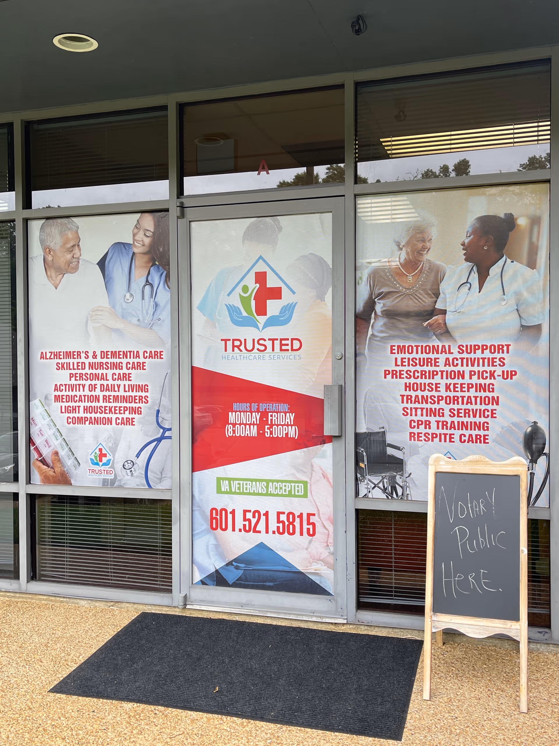 Glass storefront displaying three Trusted Healthcare Services banners and a chalkboard sign outside.