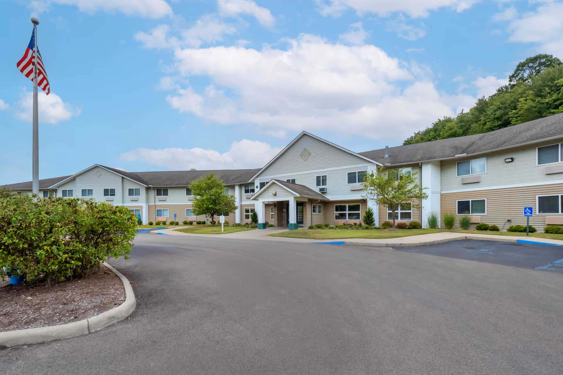 Exterior view of Brookdale Charleston Gardens, showing the building entrance and parking lot.