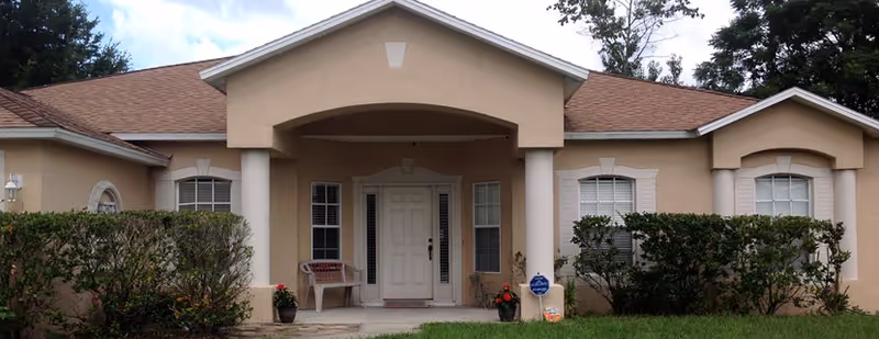 A single-story beige senior living facility with a covered entrance and columns.