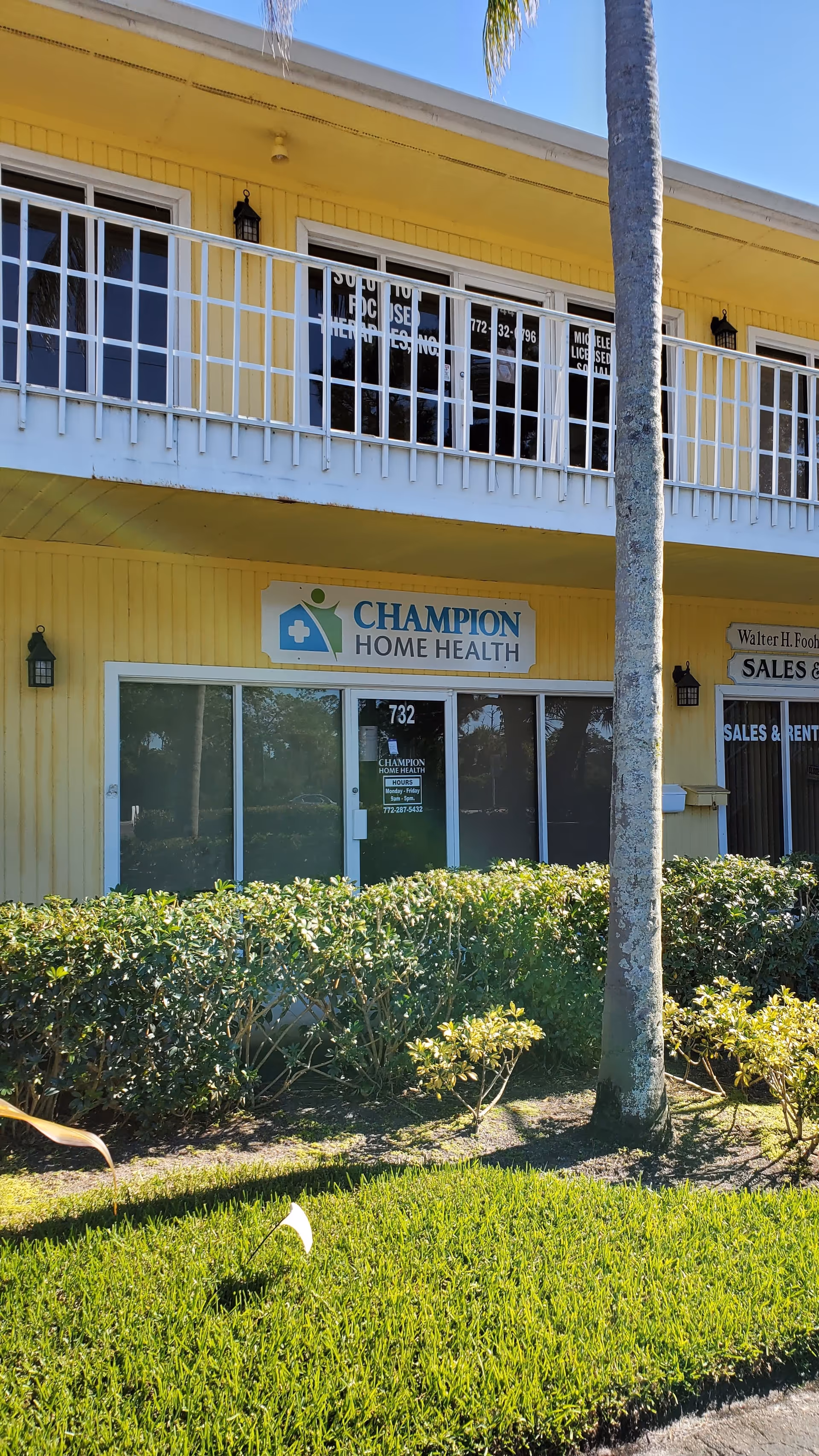 Yellow two-story building with Champion Home Health sign and glass entry doors.
