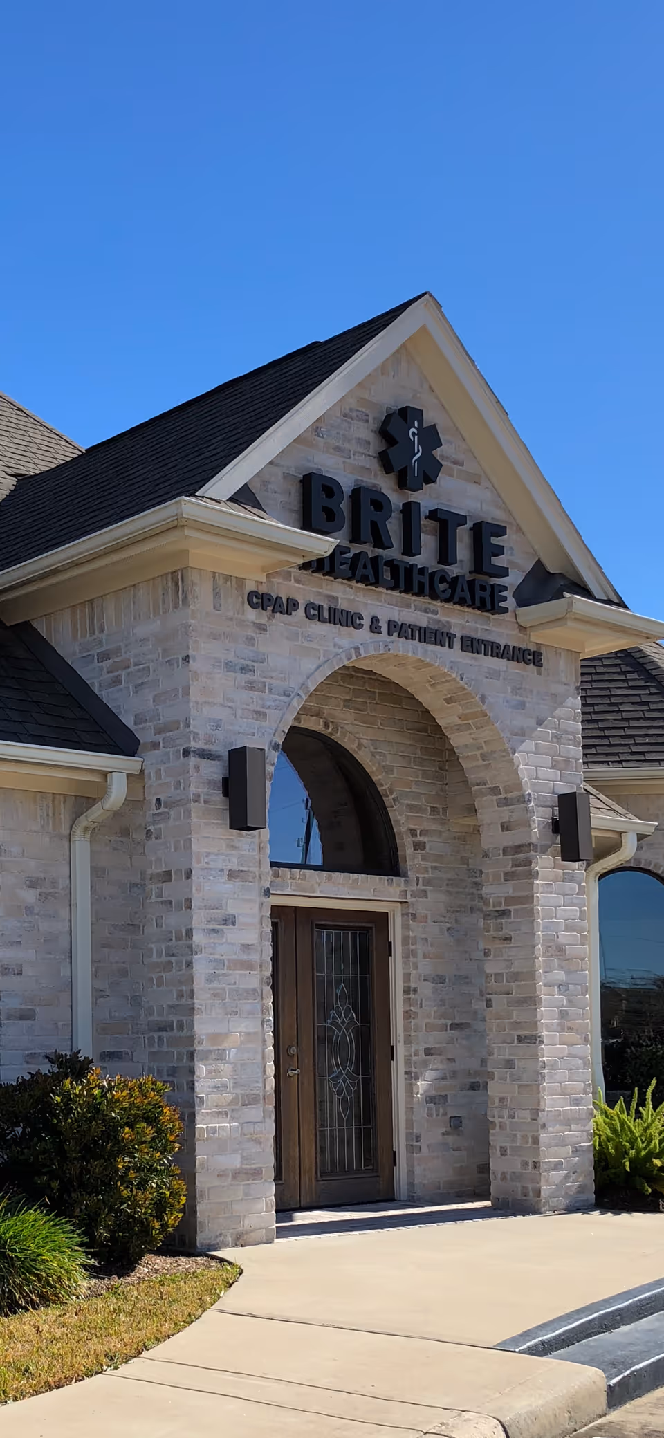 Stone brick building exterior with BRITE HEALTHCARE sign and arched entrance.