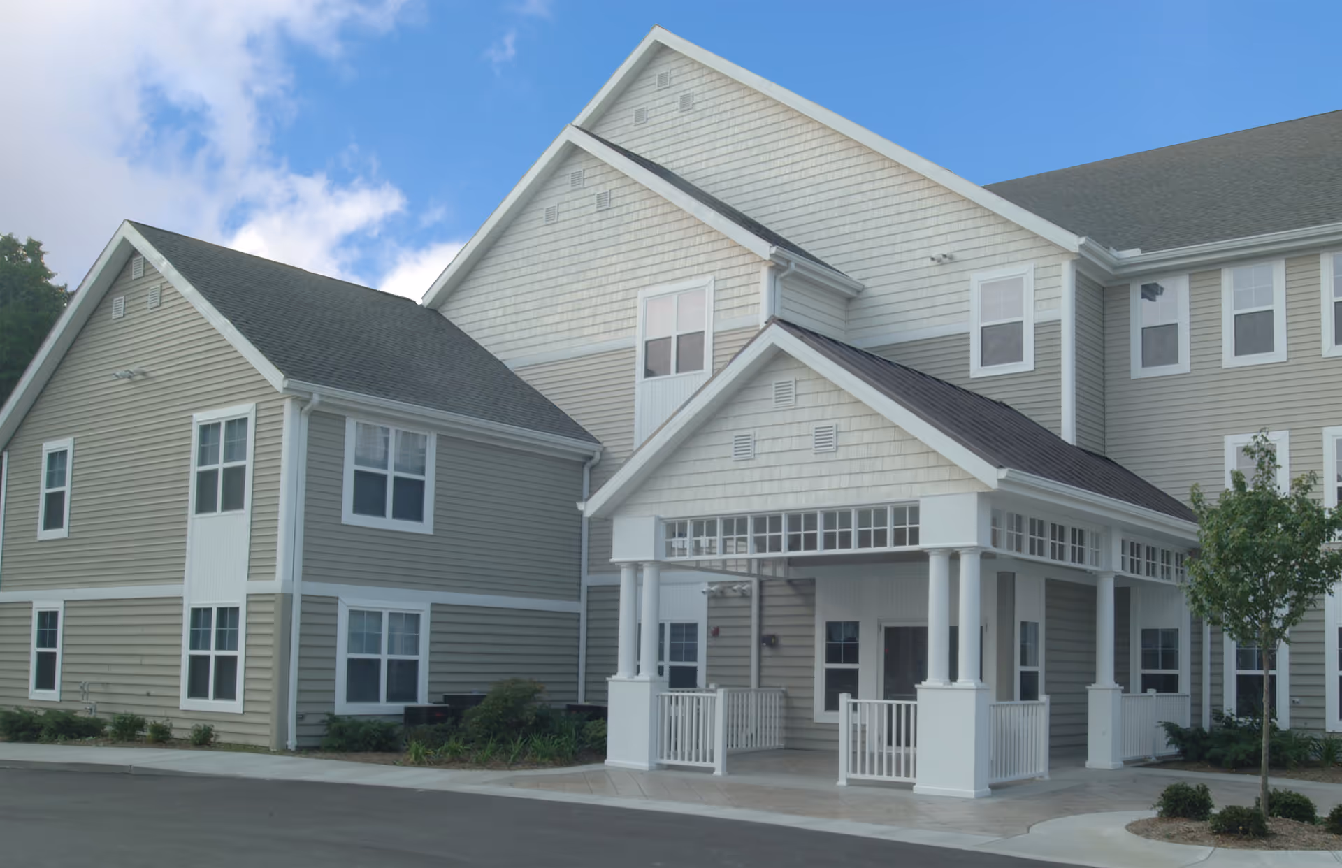 Exterior view of Jennings Assisted Living building with a covered entrance and beige siding.