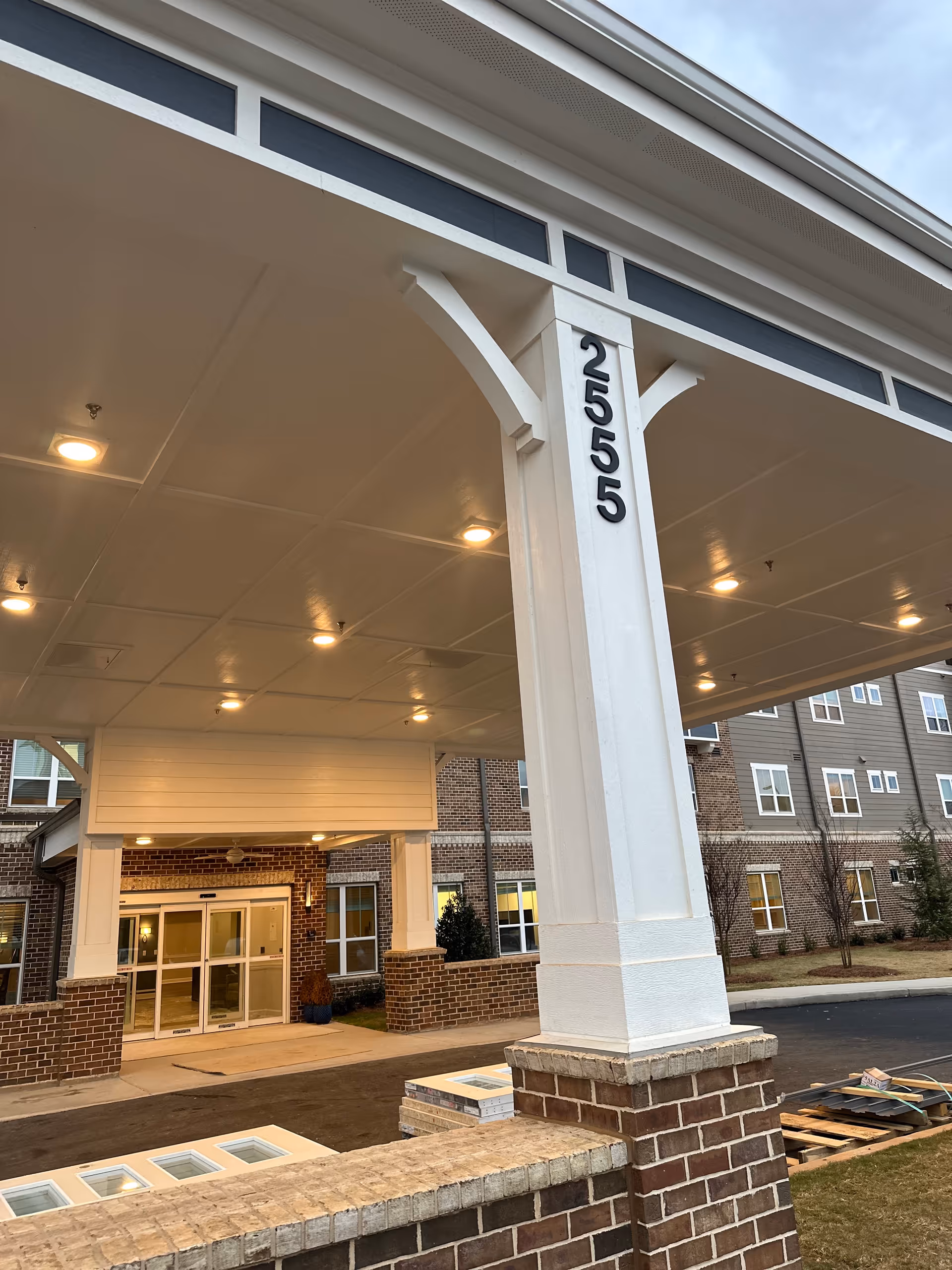 Front entrance of Harmony at Eagles Landing with a covered entryway and brick columns.