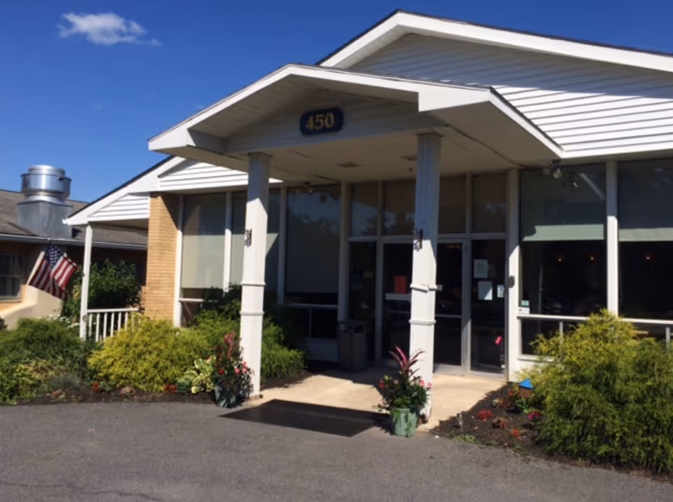 Front entrance of Hearthside Rehab Center with glass doors and landscaping.